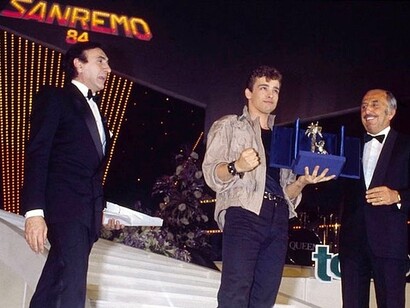 Eros Ramazzotti riceve il premio al Festival di Sanremo 1984, con lui il conduttore Pippo Baudo