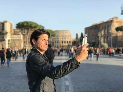 Classical archaeologist Darius Arya taking a photo of  a site in Rome, Italy