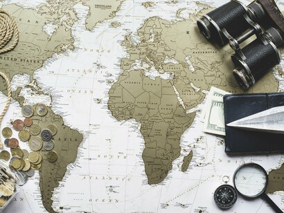 A map highlighting Africa with binoculars and money nearby, symbolizing the strategic and financial scrutiny placed on the continent