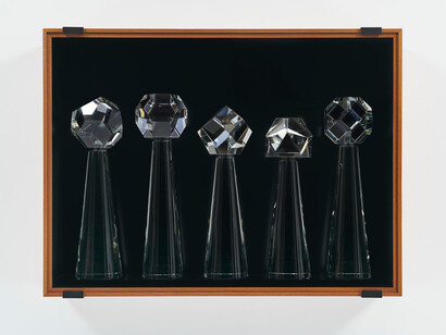 Josiah Mcelheny, From the Library of Future Geometries I, 2023. Wood, paint, hand-formed and polished solid glass cones, and geometric polyhedra shapes joined together by metal discs, patinated metal hardware, laminated museum glass, 30 x 40 x 6 in. Courtesy of James Cohan Gallery