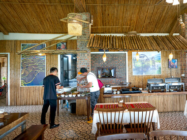The interior of a cozy, rustic restaurant with a strong bamboo and brick design theme