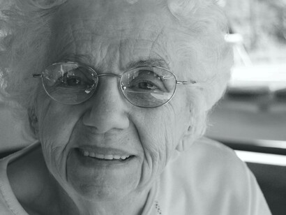 A woman in the latter stages of her life is enjoying the aging process with a smile