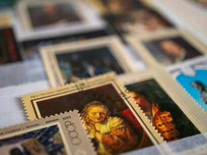 A detailed view of a table covered with stamps, reflecting a nostalgic collection of Soviet-era childhood memories