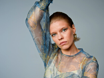 Her expression mirrors the confusion surrounding meaning and purpose, reminiscent of Magritte’s iconic commentary on perception