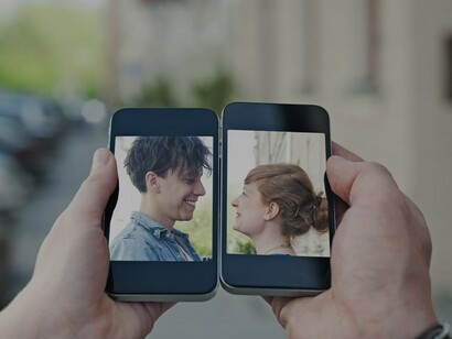 Una pareja en dos teléfonos móviles