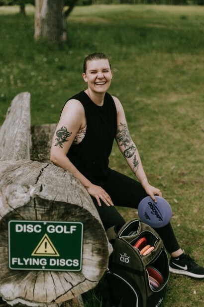 A putter disc lying on the grass at a disc golf course