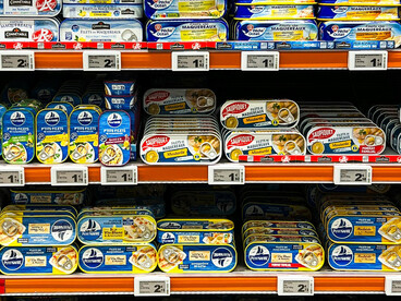Rows of brightly packaged canned fish products displayed in a French supermarket, creating a vivid and organized retail scene, Le Touquet, Hauts-de-France, France