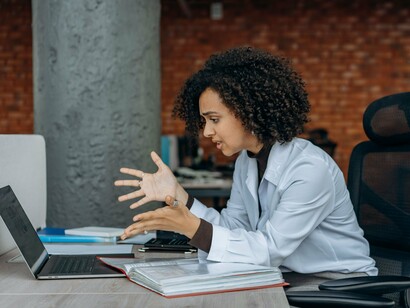 A professional experiencing a stressful moment at her workstation, representing how pressure can trigger rapid, shallow breathing