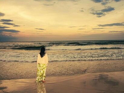 Entre o céu e as ondas, a mulher permanece imóvel. Nem toda pausa precisa produzir alguma coisa