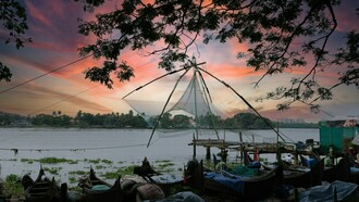Traditional Chinese fishing nets against the evening sky in Kochi, Kerala, representing the city’s centuries-old connection to maritime trade and fishing