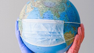 Um globo do planeta terra com máscara contra o Covid 19