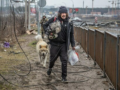 A resident leaves with his dog and belongings, Bucha, Kyiv region, 2022. Sachs proposes an international reconstruction fund to finance rebuilding on both sides of the line, with all parties contributing