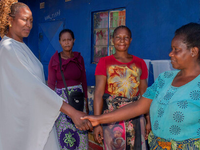 In a moment of warmth and mutual respect, the leader connects with the women, demonstrating the crucial role of local cooperation in addressing health and climate issues