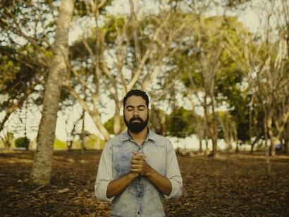 Man meditating by trees