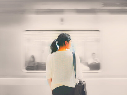 Mujer frente a un vagón de metro en movimiento en Shinjuku, Japón