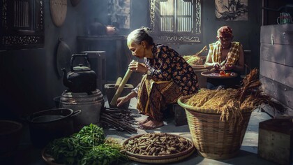 Preparing fresh herbs and natural ingredients in a traditional kitchen, representing the connection between nature and everyday wellness