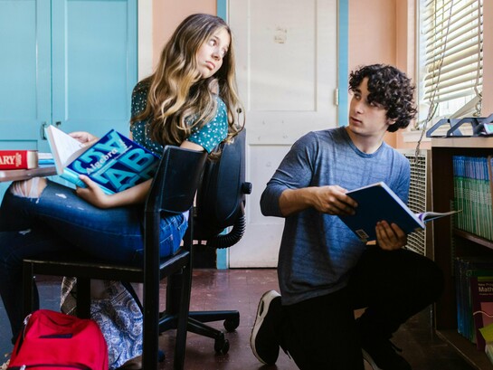 Dois estudantes compartilham livros e olhares atentos durante a atividade. A construção da autonomia e da resiliência começa justamente quando o aprendizado exige esforço, troca e enfrentamento das dificuldades