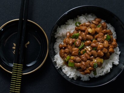 Nattō is a traditional Japanese food made by fermenting whole soybeans with Bacillus subtilis var. natto. It is typically eaten for breakfast with rice and is served with karashi mustard, soy or tare sauce, and occasionally topped with Japanese bunching onions
