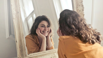 Sorriso no rosto e autoadmiração no espelho 