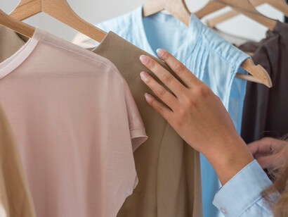 A woman reviewing new eco-friendly clothes, including sustainable fashion pieces made from organic cotton and recycled fabrics