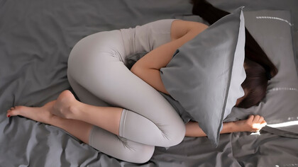 A woman tightly clutching a pillow, seeking a sense of comfort, solace, or emotional support