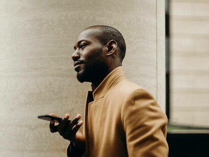 A young African businessman is doing deals over his smartphone