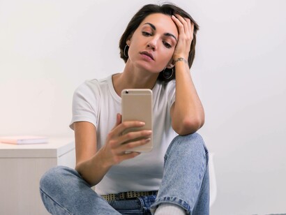 Donna che guarda lo smartphone: "L’utilizzo dello smartphone sregola il ciclo dopaminergico e di abitua ad avere scariche di dopamina senza la fatica connessa per ottenerla..."