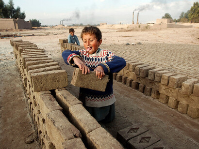 Niños trabajando en la construcción de un muro
