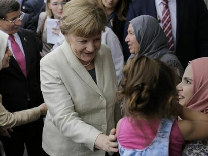 Angela Merkel with a group of migrants
