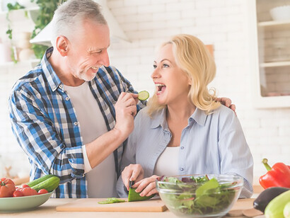 Transform your health journey with a captivating portrayal of a senior couple immersed in the Mediterranean diet, focusing on antioxidant-rich foods as they prepare a salad and engage with a digital tablet in their kitchen