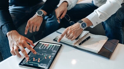 Two people looking at data on a tablet 