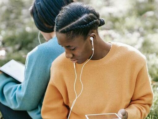 A woman listening to a podcast on mental health outdoors