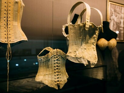 Mannequins showcasing an assortment of vintage corsets in a glass display