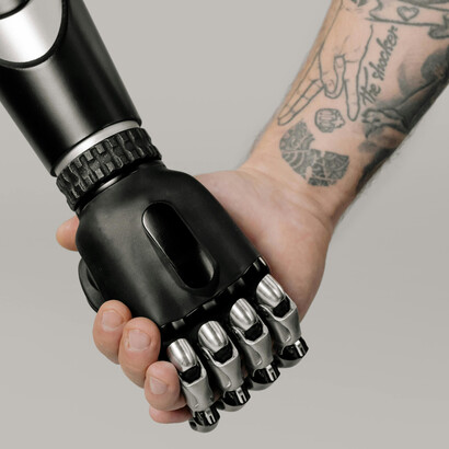 A human hand reaches out to touch a robotic hand, symbolizing the connection between humans and AI
