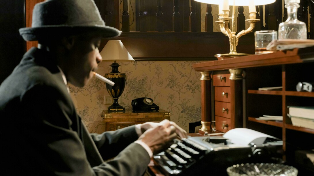 Detetive escreve uma carta em uma máquina de escrever