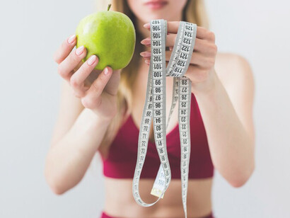 A sporty woman in a kitchen setting embodies the diet concept, amidst discussions of miracle diets, fake health claims, and nutrition misinformation