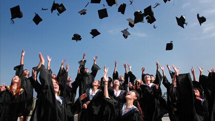 A group of university students posing for a graduation photo