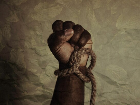 A bound hand clenched in resistance, the rope tightening around the wrist as a stark reminder of how slavery reduced human beings to property