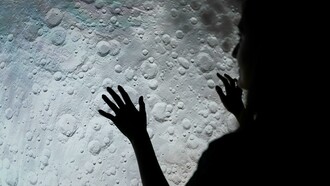 A woman examines a picture of the moon's surface