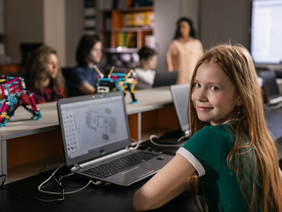 Aluna usa comandos de programação que aprendeu durante aula para ensinar um mini robô