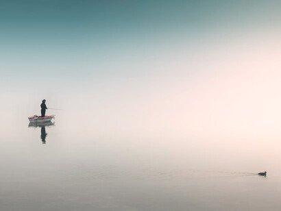 Reflejo de un pescador en el agua del lago al amanecer. El contacto permanente con la tierra despierta los sentidos e incluso estimula la expansión de las capacidades ocultas del cerebro