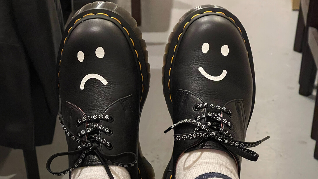Sapatos pintados com um sorrio triste e outro sorriso feliz refletem nossas alegrias e dores em estados diferentes ao longo da vida
