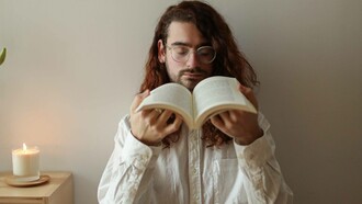 Homem abre um livro novo para sentir o cheiro das páginas 
