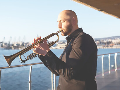 Immerse in a jazz-filled day as adult passionately play the trumpet by the seaside, harmonizing musical notes with the serene sounds of the sea