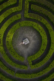 Porto, Portugal, a woman stands in the center of a labyrinth, framed by twisting paths and quiet symbolism