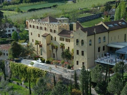 Uno scorcio di Castel Trauttmansdorff , si nota la vegetazione mediterranea contrassegnata dai sottili e alti cipressi e dalla massa grigia delle chiome degli olivi, a testimonianza della mitezza del clima del luogo.   

