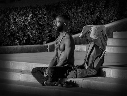 A man sits on the steps in a meditative state