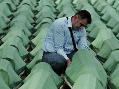 Hombre llora en un sepelio de las víctimas identificadas de la masacre de Srebrenica. Para julio de 2012, 6,838 víctimas han sido identificadas a través de análisis de ADN de las partes del cuerpo que se recuperaron de las fosas comunes​ y 5,657 víctimas han sido enterradas