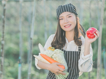 A chef gathers fresh produce from an organic farm, showcasing the benefits of sustainable agriculture and organic farming practices