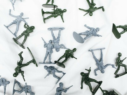 Miniature military figures on a white surface, symbolizing the enduring prominence of armed posturing in the region